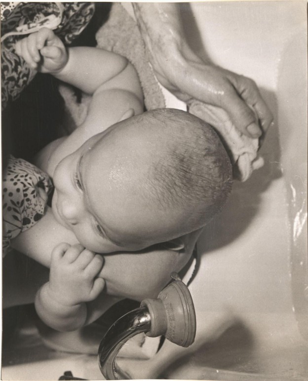 Mother washing her baby's head with a cloth