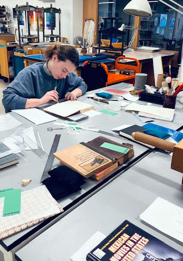 Student Emma works on a book from the collection